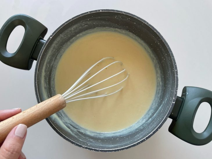 Creme sendo mexido no fogo até engrossar levemente.