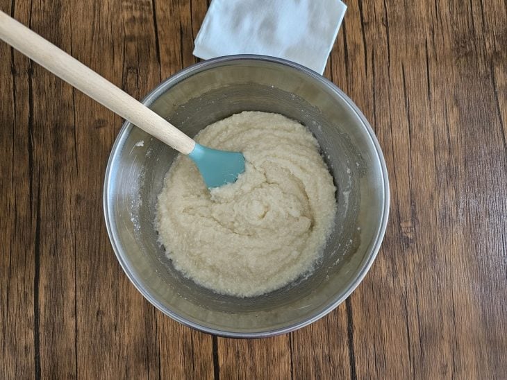 Um recipiente contendo a mistura de tapioca granulada, manteiga, leite quente e açúcar.