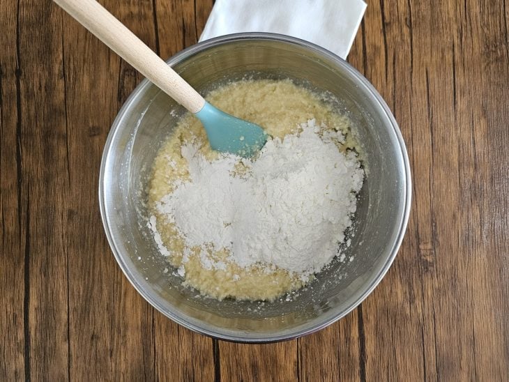 Um recipiente contendo a mistura de tapioca granulada, manteiga, leite quente, açúcar, ovos e amido de milho.