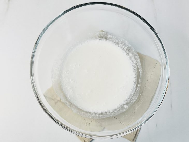 Tapioca granulada com água e leite de coco em um recipiente.