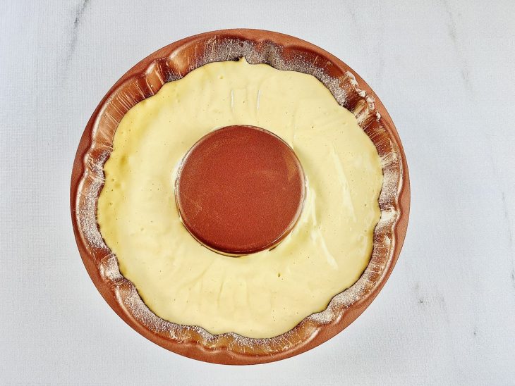 Massa sendo transferida para forma redonda de furo central.