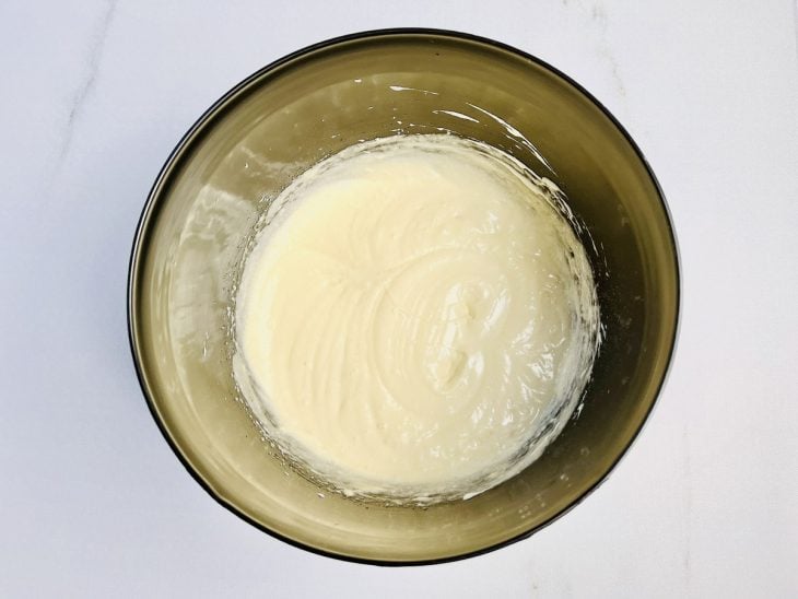 Ingredientes misturados em uma tigela com auxílio de um fouet.