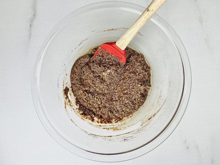 Aveia, achocolatado, cacau em pó e leite adicionados a tigela.