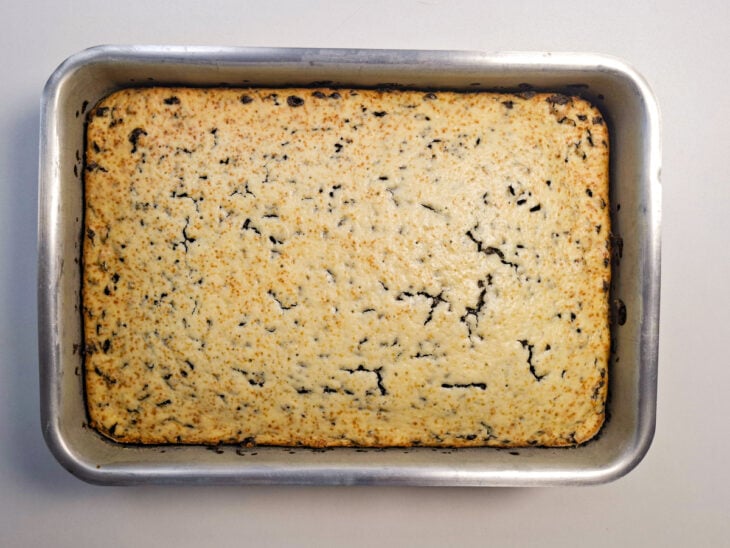 Bolo assando no forno até ficar dourado e firme.