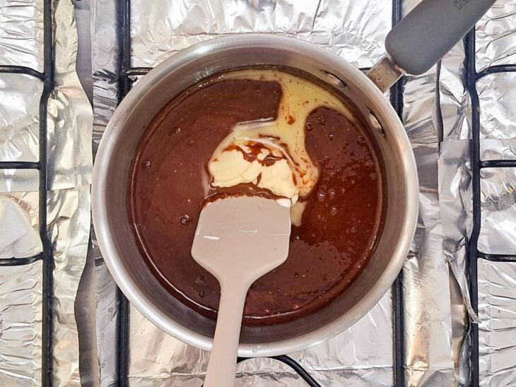 Ingredientes da cobertura sendo misturados na panela durante o cozimento.
