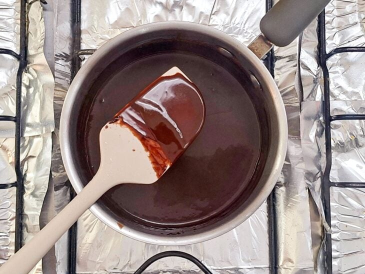 Cobertura cremosa de chocolate atingindo o ponto após alguns minutos de fervura.