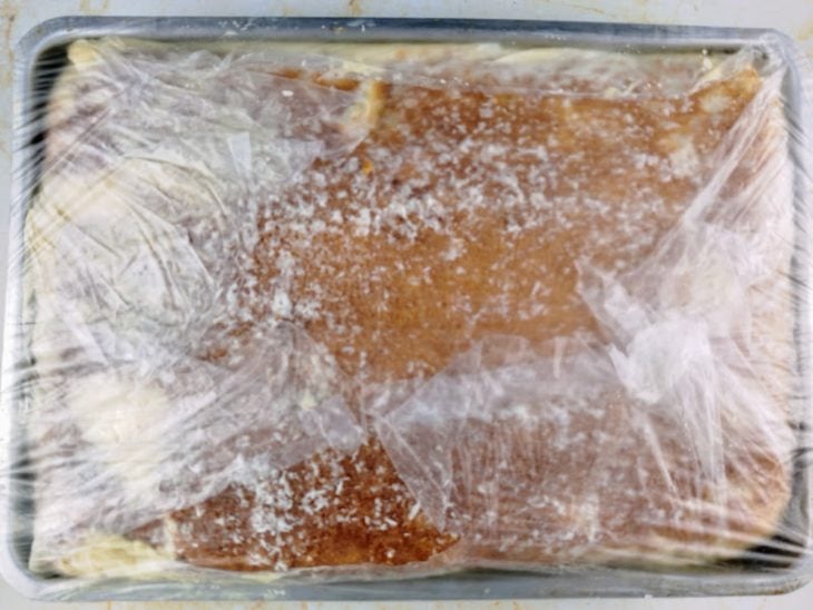 Bolo montado e coberto por plástico.