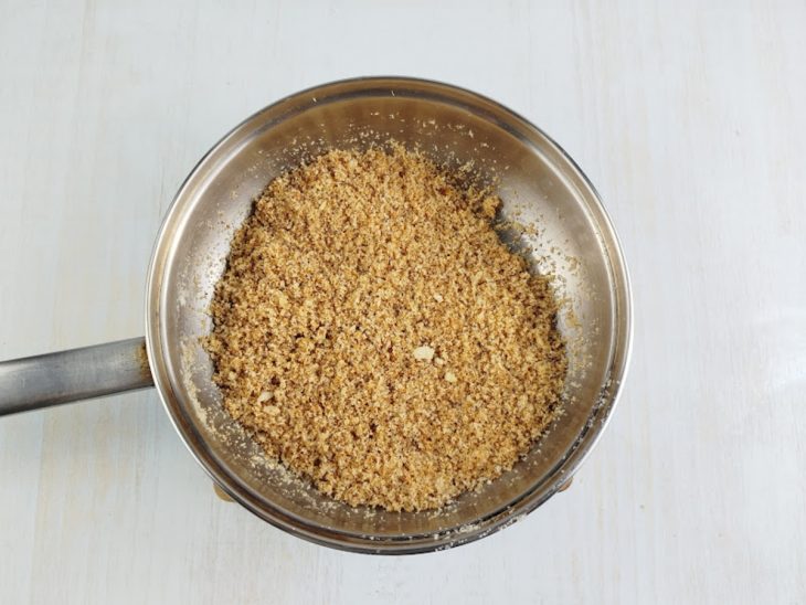 Na frigideira, o coco ralado dourado na manteiga.