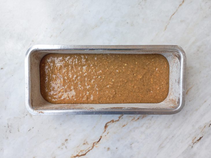 Metade da massa do bolo despejada na forma.