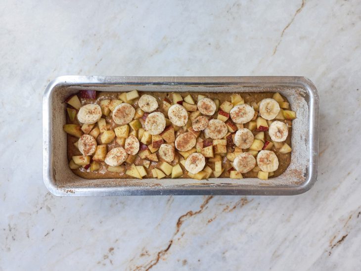 Banana, maçã e canela polvilhada na assadeira.