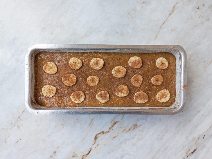 Massa do bolo colocada sobre as frutas e rodelas de banana colocadas para finalizar.