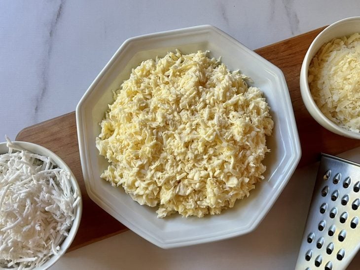 Recipientes com mandioca, queijo e coco ralados.