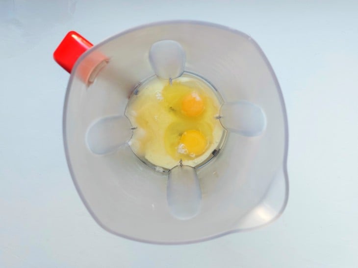 Um liquidificador com ovos, leite, óleo e açúcar.