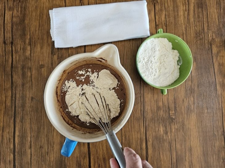 Uma tigela contendo a mistura de ovos, açúcar, óleo, leite, chocolate em pó e farinha.