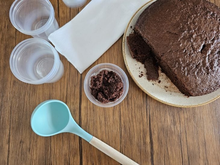 Um pote forrado com creme branco e coberto com pedaços de chocolate.