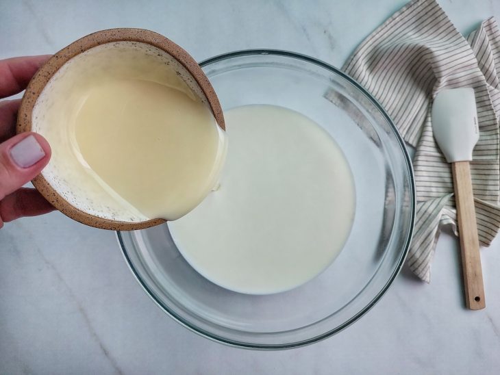 Leite quente misturado com leite condensado em tigela grande.