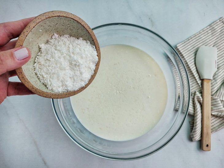 Coco ralado e pitada de sal distribuídos na mistura.