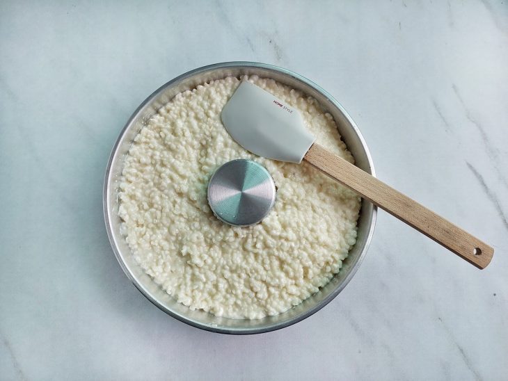 Massa transferida e nivelada na forma untada.