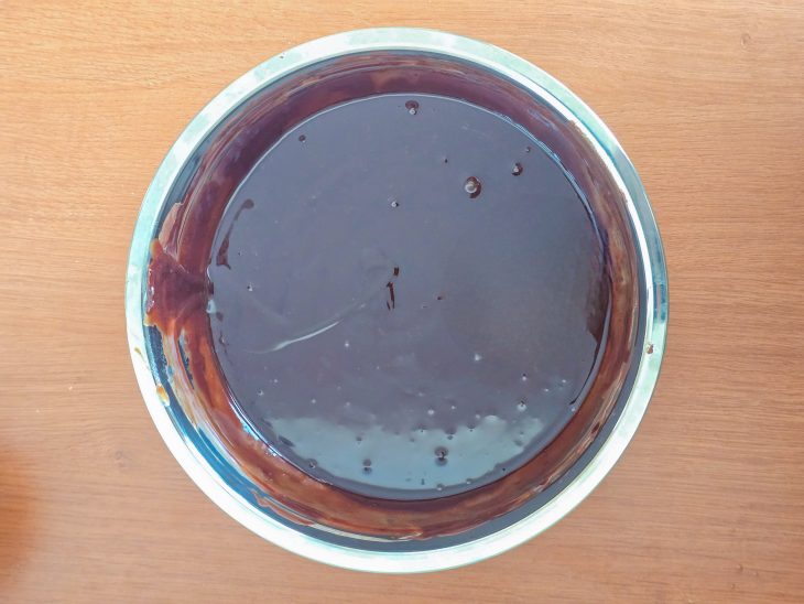 Chocolate derretido misturado ao creme de leite numa tigela.