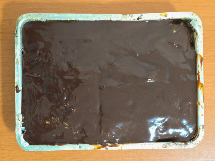 Secunda meta da massa adicionada, por cima a ganache de chocolate.