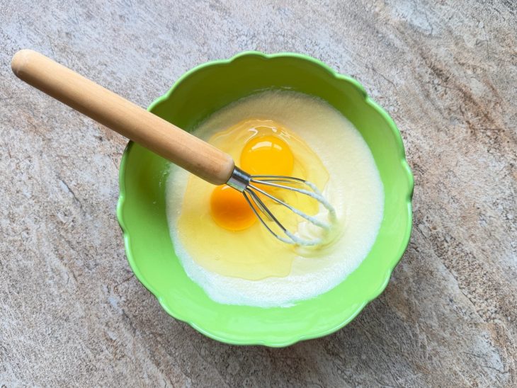 Ovos acrescidos na tigela com o açúcar e manteiga.