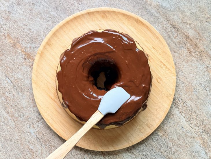 Ganache despejada por cima do bolo.