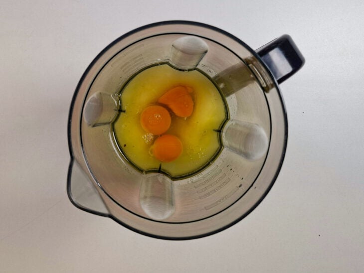 Ovos, óleo e açúcar sendo batidos no liquidificador para preparar a massa do bolo.