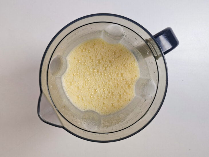 Ingredientes do pudim sendo batidos no liquidificador até obter uma mistura uniforme.