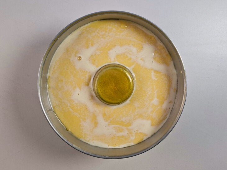 Mistura do pudim passando por uma peneira fina antes de ser adicionada à forma.
