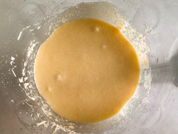 Coco e queijo sendo adicionados à massa e misturados.