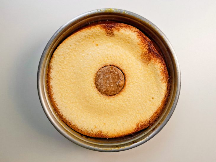 Bolo recém-assado com topo dourado, ainda na forma.