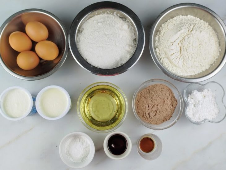 Ingredientes para a receita de bolo red velvet fácil e rápido separados em uma bancada.