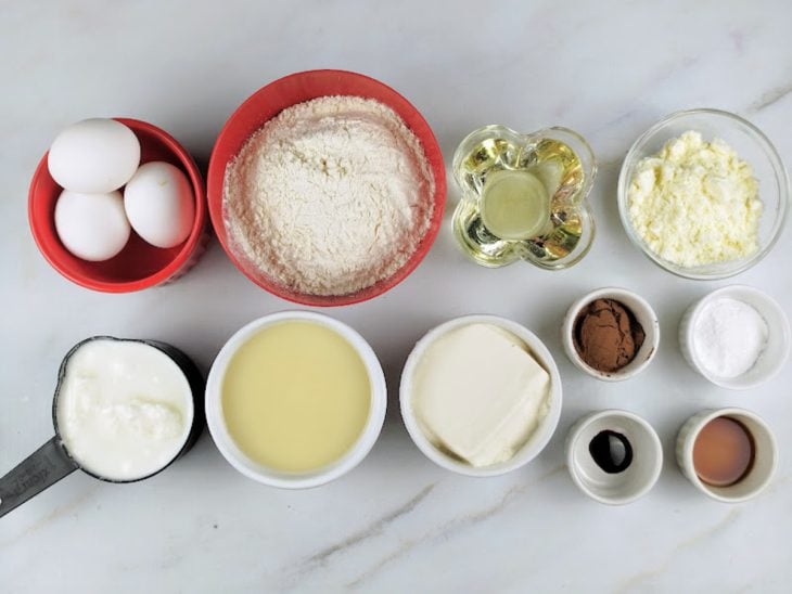 Ingredientes para a receita de bolo red velvet separados em uma bancada.