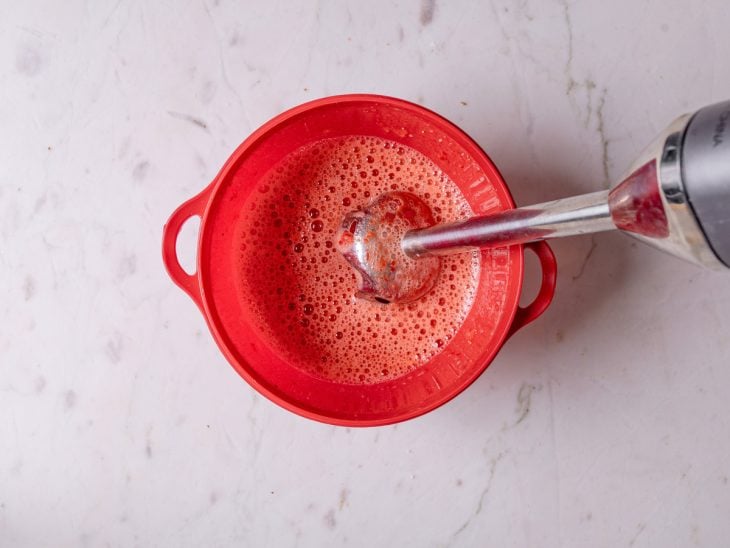 Mixer e tigela com a mistura da geleia de morango.