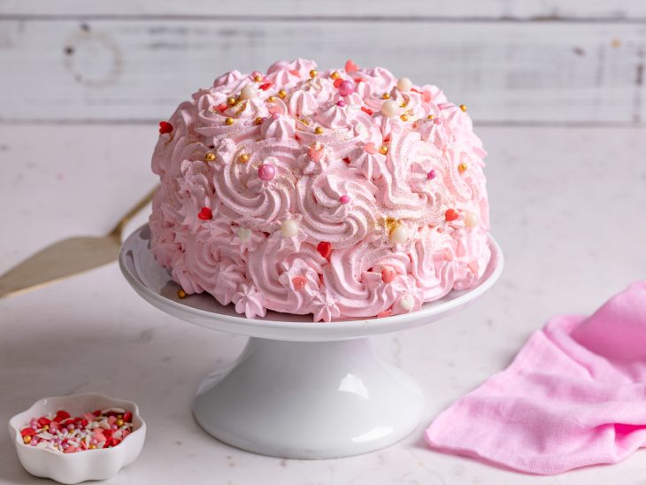 Uma boleira com bolo rosa.
