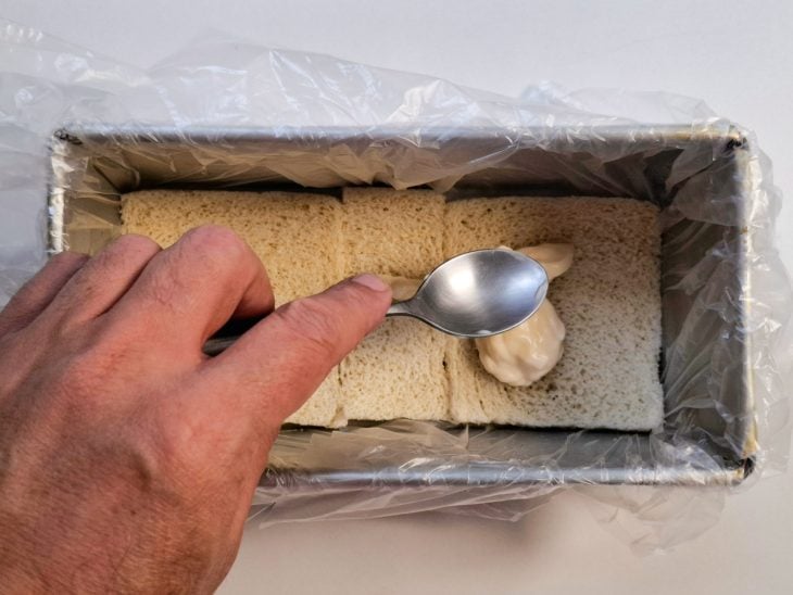 Camada de maionese sobre as fatias de pão.