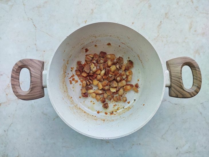 Cubos de frango dourados na panela.