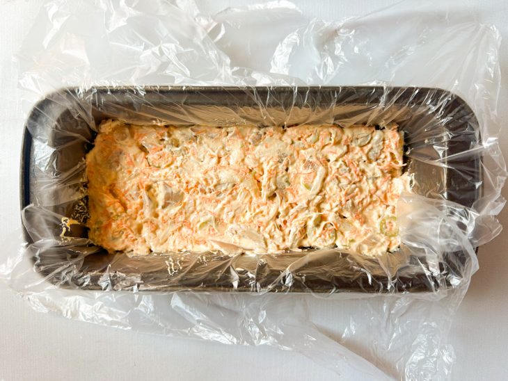 Primeira camada de pão e recheio na forma.