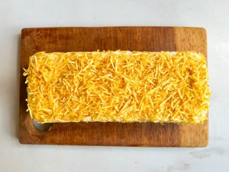 Batata palha distribuídas por cima do bolo salgado.