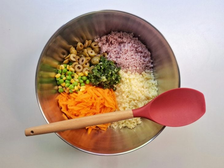 Queijo, presunto, cenoura, milho e ervilha, azeitonas, sal, salsinha, pimenta e orégano em um recipiente de alumínio.