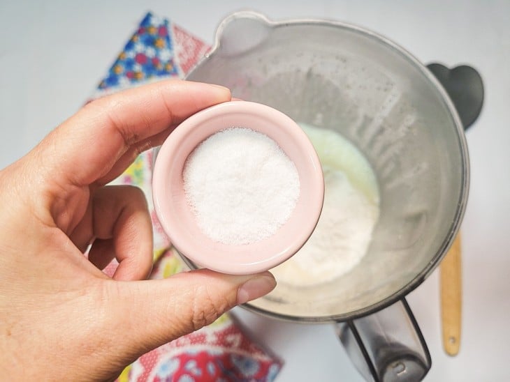 ingrediente em pó na cor branca sendo adicionado ao liquidificador.