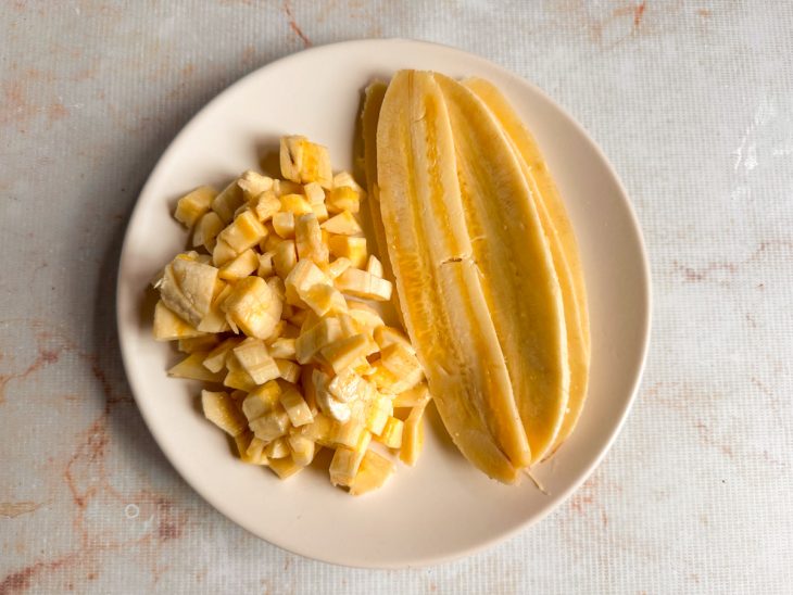 Bananas cortadas em cubinhos e uma banana fatiada para decorar.