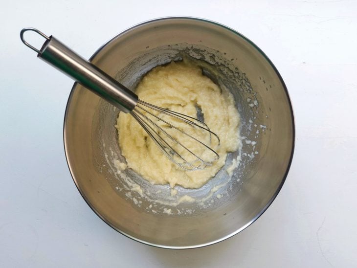 Um recipiente contendo a mistura de açúcar e manteiga derretida.