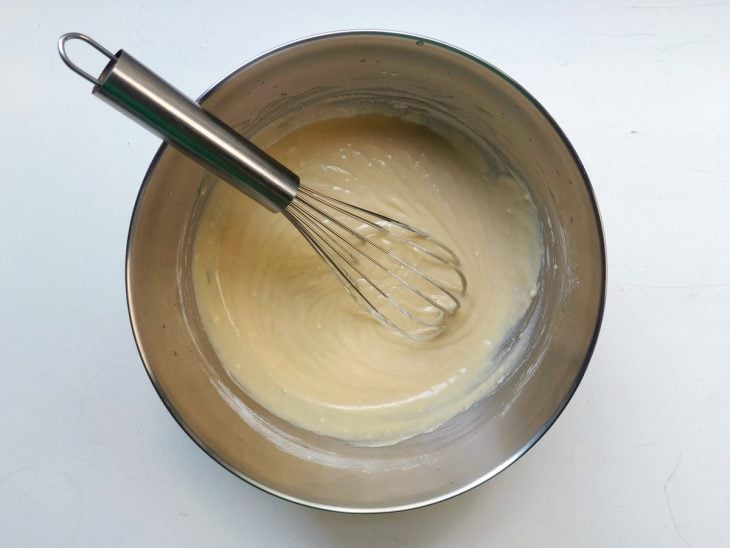 Um recipiente contendo a mistura de açúcar, manteiga derretida, água e farinha.