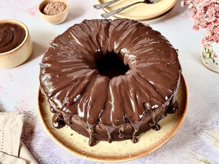 Bolo simples de chocolate finalizado com calda de chocolate e pronto para consumo.