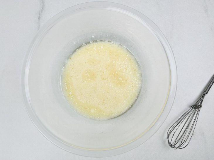 Ingredientes misturados em uma tigela redonda de vidro.