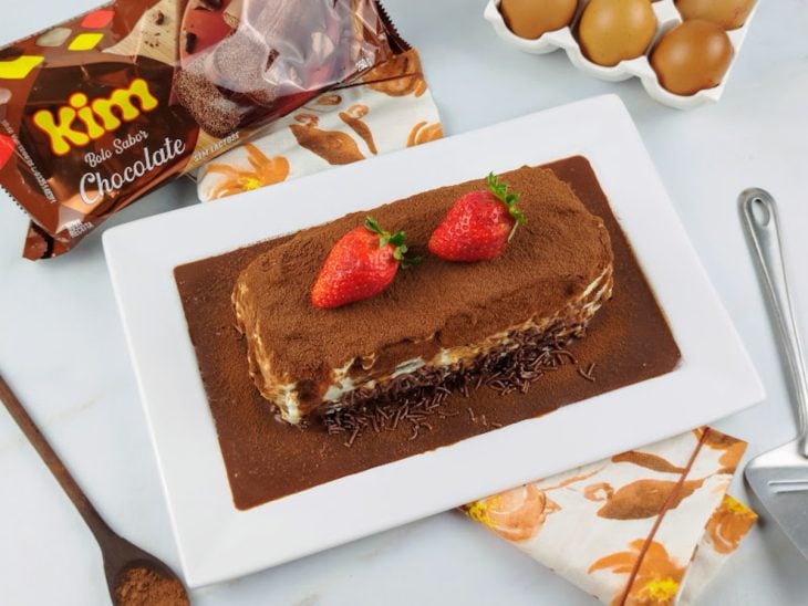 Bolo tiramisú finalizado com morangos e pronto para servir.