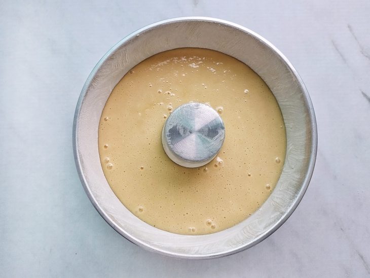 Massa crua despejada na forma com furo central já preparada.