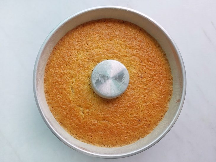 Bolo assado dourado dentro da forma após sair do forno.