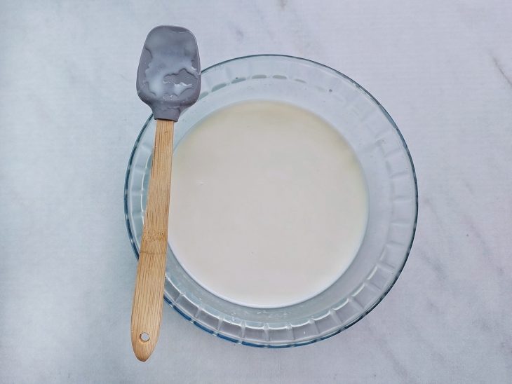 Calda branca homogênea misturada dentro da tigela.